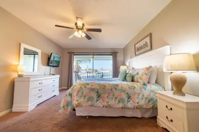 a bedroom with a bed and a ceiling fan at Edgewater Villa 907 'Flamingo Sunset' in Panama City Beach
