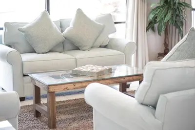 a living room with a couch and a table at Edgewater Villa 907 'Flamingo Sunset' in Panama City Beach