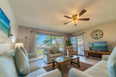 a living room with a couch and a ceiling fan at Edgewater Villa 907 'Flamingo Sunset' in Panama City Beach