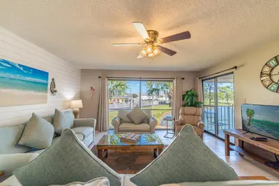 a living room with a couch and a ceiling fan at Edgewater Villa 907 'Flamingo Sunset' in Panama City Beach