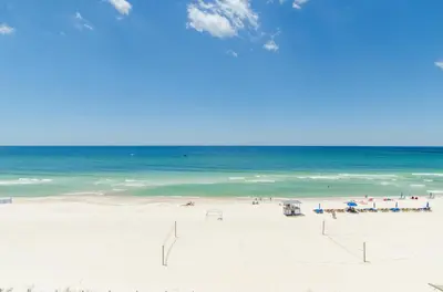 a group of people on a beach with the ocean at Edgewater 3-0413 'Once Upon A Tide' in Panama City Beach