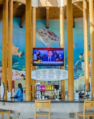 a bar with a television on the wall of a seafood restaurant at Edgewater 3-0413 'Once Upon A Tide' in Panama City Beach