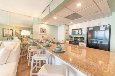a kitchen and living room with a large counter top at Edgewater 3-0810 'Alpaca My Bags' in Panama City Beach