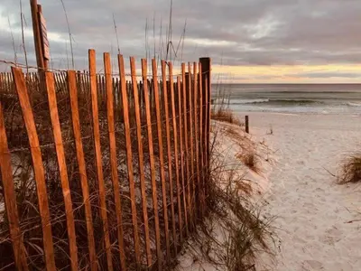 a wooden fence on the beach near the ocean at Sugar Beach E7 'Ocean Seven' in Panama City Beach