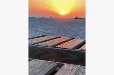 a boat on the beach with the sunset in the background at Sugar Beach E7 'Ocean Seven' in Panama City Beach