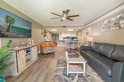 a living room with a couch and a ceiling fan at Sugar Beach E7 'Ocean Seven' in Panama City Beach