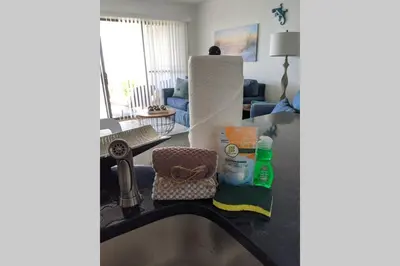 a kitchen counter with a sink and a living room at Oceanfront Paradise - Beach at your backdoor!! in Panama City Beach