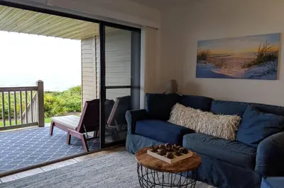 a living room with a blue couch and a table at Oceanfront Paradise - Beach at your backdoor!! in Panama City Beach