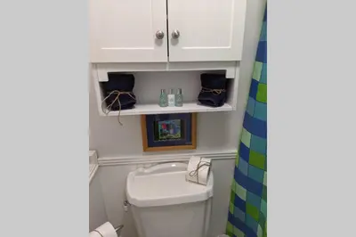 a bathroom with a white cabinet above a toilet at Oceanfront Paradise - Beach at your backdoor!! in Panama City Beach