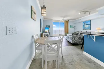 a kitchen and dining room with a table and chairs at Tidewater 2804 in Panama City Beach