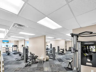 a gym with treadmills and machines in a room at Tidewater 2804 in Panama City Beach