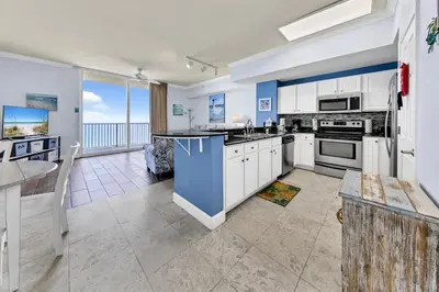 a kitchen with white cabinets and a view of the ocean at Tidewater 2804 in Panama City Beach