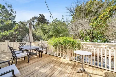 a patio with tables and chairs on a wooden deck at Daze Gone Bye in Panama City Beach