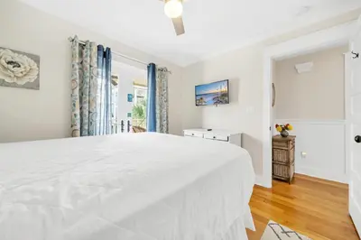 a white bedroom with a large bed and a window at Daze Gone Bye in Panama City Beach
