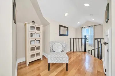 a living room with a chair and a staircase at Daze Gone Bye in Panama City Beach