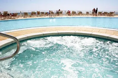 a large pool of water with people sitting on chairs at Emerald Beach 1535 in Panama City Beach