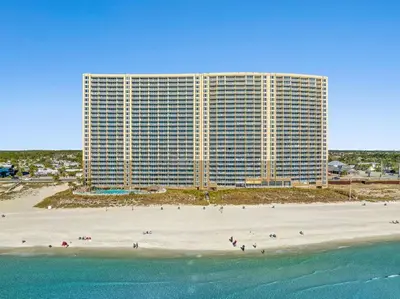 a large building on a beach next to the ocean at Emerald Beach 1535 in Panama City Beach