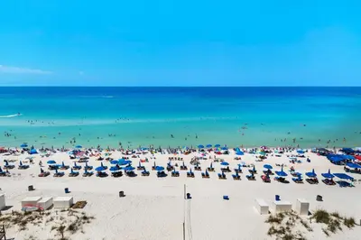a beach with a large crowd of people and the ocean at Majestic Beach Towers 1-609 in Panama City Beach