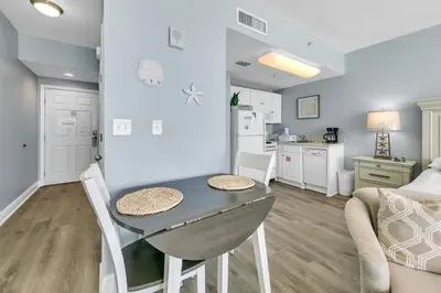 a kitchen and dining room with a table in a room at Majestic Beach Towers 1-609 in Panama City Beach