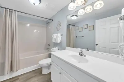 a white bathroom with a sink and a toilet at Majestic Beach Towers 1-609 in Panama City Beach
