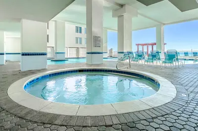 a pool in the middle of a building with chairs at Majestic Beach Towers 1-609 in Panama City Beach