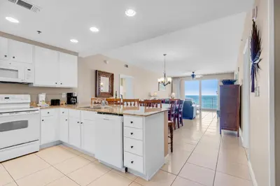 a kitchen with white cabinets and a view of the ocean at Splash 207E in Panama City Beach