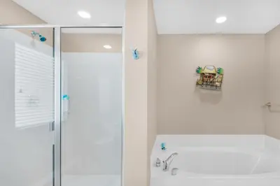 a white bathroom with a shower and a sink at Splash 207E in Panama City Beach