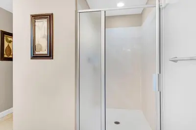 a shower stall in a bathroom with white walls at Splash 207E in Panama City Beach