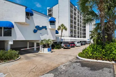 a parking lot in front of a building with palm trees at Aquavista 404E in Panama City Beach