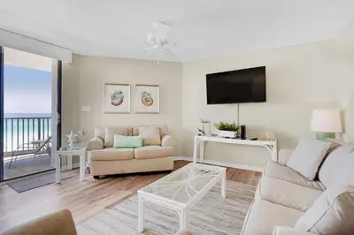 a living room with a couch and a tv at Aquavista 404E in Panama City Beach