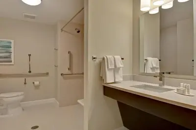 a bathroom with a sink and a toilet and a mirror at TownePlace Suites by Marriott Panama City Beach Pier Park in Panama City Beach