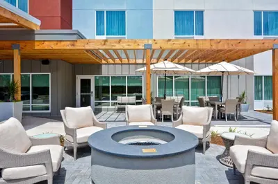a patio with chairs and a fire pit in front of a building at TownePlace Suites by Marriott Panama City Beach Pier Park in Panama City Beach
