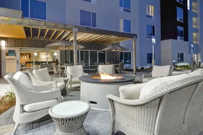 a patio with chairs and a fire pit and a building at TownePlace Suites by Marriott Panama City Beach Pier Park in Panama City Beach