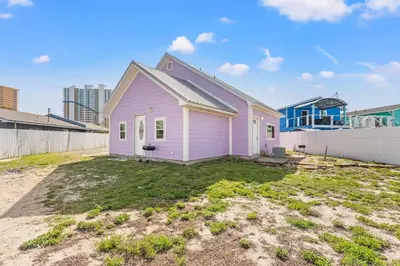 a pink house is sitting in a yard at 5218 Beach Dr C in Panama City Beach