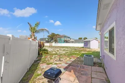 a yard next to a house with a fence at 5218 Beach Dr C in Panama City Beach