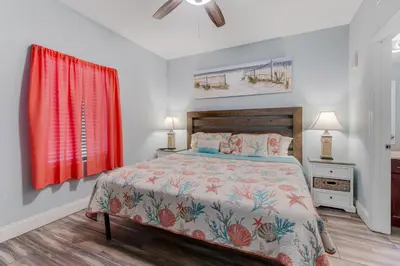 a bedroom with a bed and a red curtain at Laketown Wharf 335! 1 BD, 2 Bathroom with Amazing Amenities in Panama City Beach