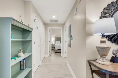 a hallway with a desk and a lamp on a table at Sterling Reef 802 in Panama City Beach