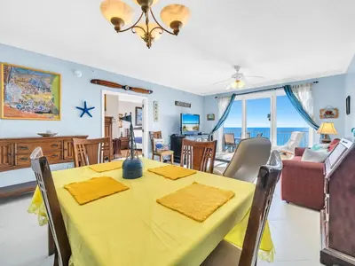 a dining room with a yellow table and chairs at Grandview East 1004 in Panama City Beach