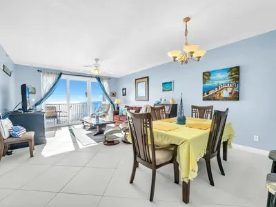 a dining room and living room with a table and chairs at Grandview East 1004 in Panama City Beach