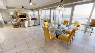 a dining room and living room with a table and chairs at Marisol 1001 in Panama City Beach