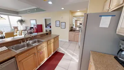 a kitchen with a sink and a refrigerator at Marisol 1001 in Panama City Beach