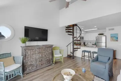 a living room with a table and chairs and a kitchen at Mistral Unit 18 in Santa Rosa Beach