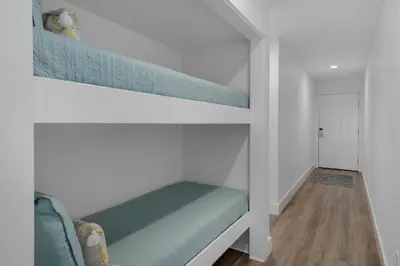 a bedroom with two bunk beds and a hallway at Mistral Unit 18 in Santa Rosa Beach