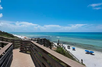 a wooden pathway to the beach with chairs and umbrellas at Mistral Unit 18 in Santa Rosa Beach