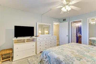 a bedroom with a bed and a flat screen tv at Oceanfront PCB Condo Steps to Private Beach! in Panama City Beach