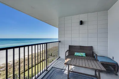a bench on a balcony with a view of the beach at Oceanfront PCB Condo Steps to Private Beach! in Panama City Beach