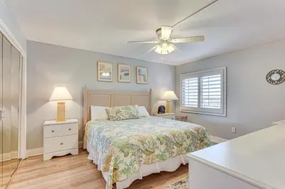 a bedroom with a bed and a ceiling fan at Oceanfront PCB Condo Steps to Private Beach! in Panama City Beach