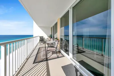 a balcony with a table and chairs and the ocean at Majestic Beach Towers 1-1803 in Panama City Beach