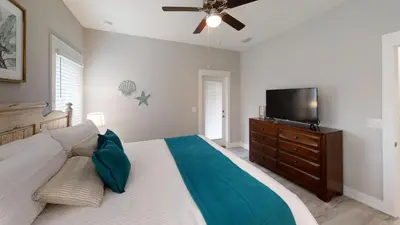 a bedroom with a bed and a flat screen tv at Seabreeze 114 in Panama City Beach