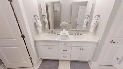 a white bathroom with a sink and a mirror at Seabreeze 114 in Panama City Beach